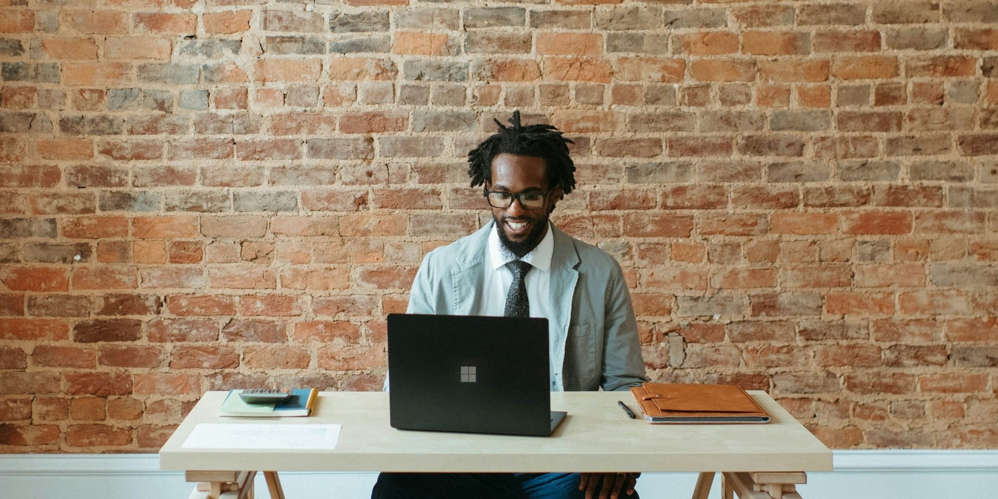 a man sitting at a table with a laptop on it
