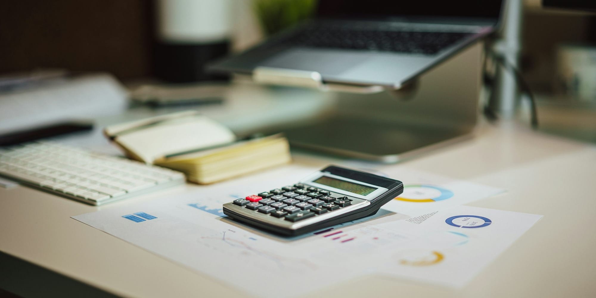 a calculator sitting on top of a table next to a laptop